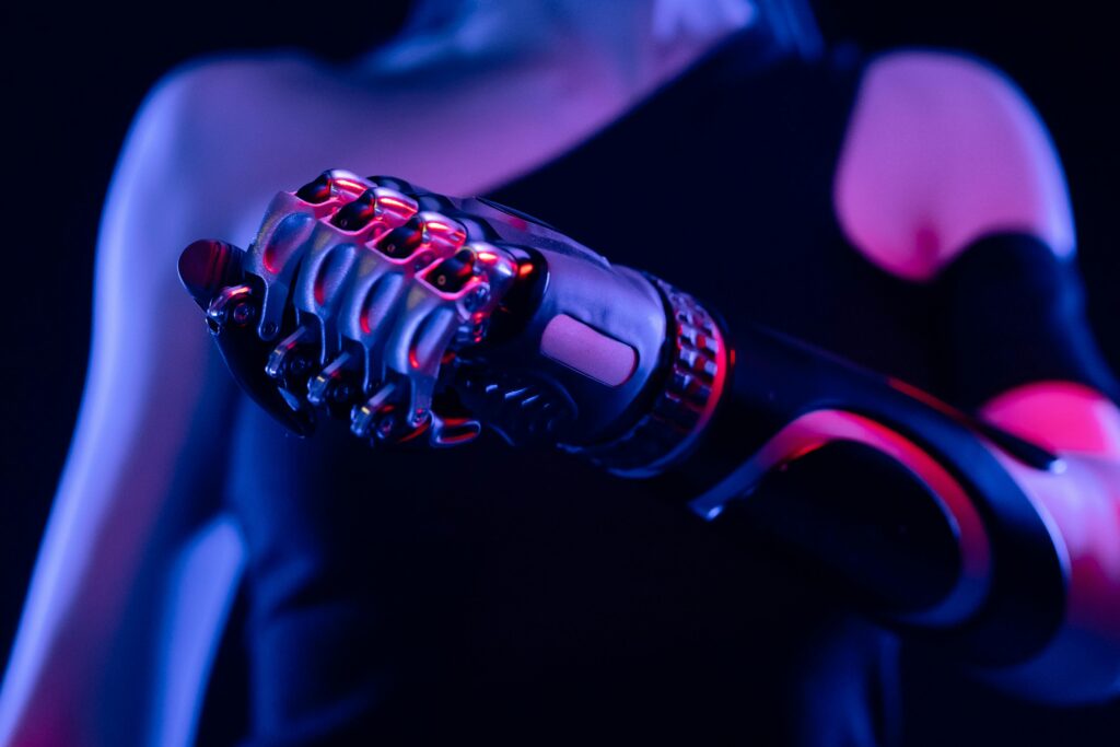 Close-up of a robotic prosthetic hand in neon lighting, symbolizing advanced technology.